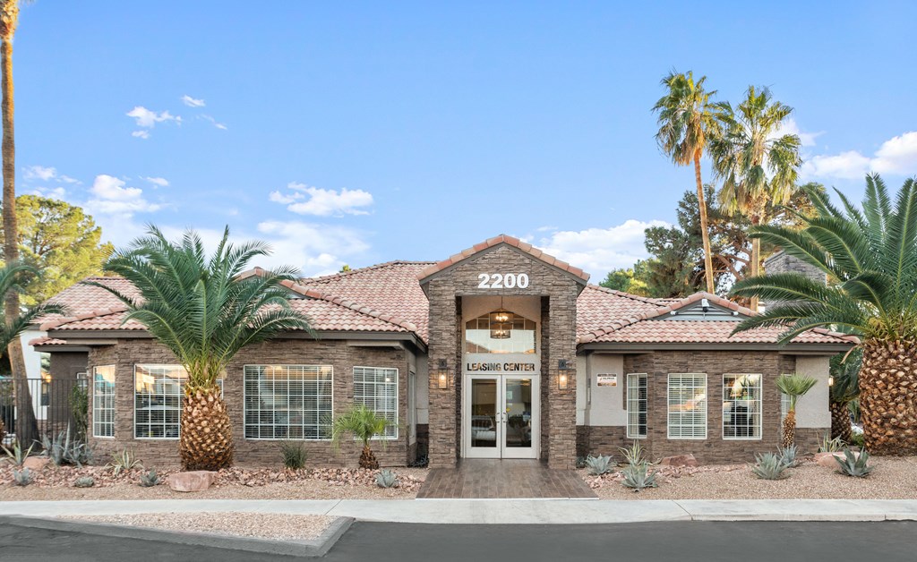 a home with a tile roof and palm trees in front of it